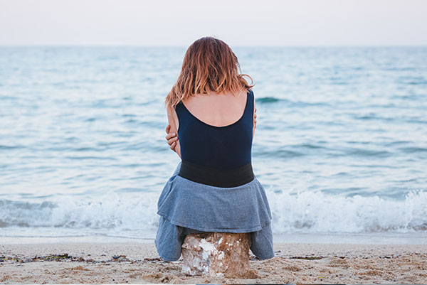 Grieving woman sitting at the beach